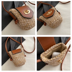 Detail view of mini straw crossbody bag featuring leather flap and gold twist lock