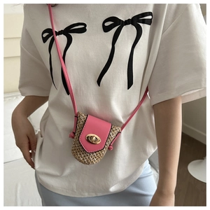 Mini straw crossbody bag featuring pink leather flap and gold twist-lock on a female model