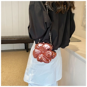 Detail of rose gold flower-shaped hard shell clutch bag with gold metal chain strap