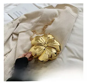 Close-up of gold flower-shaped evening clutch bag with metallic chain strap