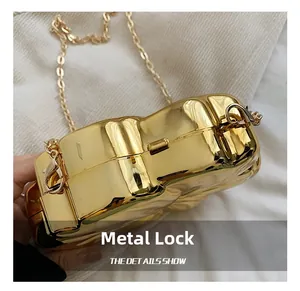 Detailed close-up of the bright gold shell-shaped clutch with its hardware clasp and chain