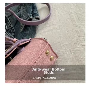 Vue détaillée du fond du sac en cuir rose avec des clous de protection dorés