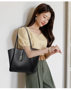 Model wearing a black lychee texture tote bag with gold buckle on casual outfit