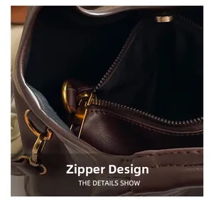 Detail shot of internal gold zipper and metal ring on dark brown leather handbag