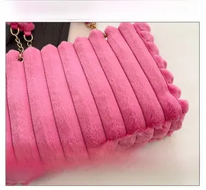 Detail of pink faux fur shoulder bag featuring soft vertical stripes and gold metal chain