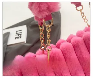 Detailed shot of fluffy pink faux fur striped texture and gold metal chain links
