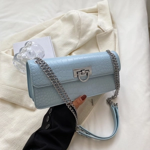 Close-up of light blue crocodile embossed leather texture with silver metal square buckle