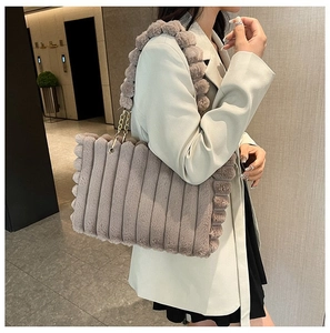Detail of grey-purple faux fur tote bag showing striped stitching and plush ball strap
