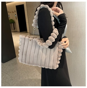 Model wearing a large striped plush tote bag in beige faux fur for autumn winter fashion