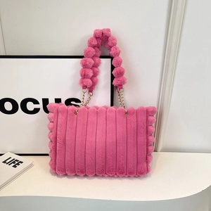 Detailed macro view of pink plush handbag with striped texture and soft pom-pom handles