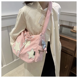 Détail du sac à bandoulière en velours côtelé rose avec étoiles en peluche et poche zippée