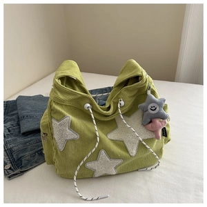 Détail du sac à main en velours côtelé vert avec étoiles en polaire et cordon de serrage