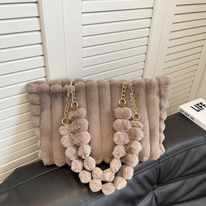 Detail of taupe faux fur tote bag featuring vertical stripes and gold metal chain strap