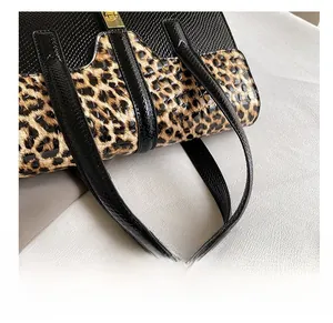 Detail showing high-quality leopard print pattern and metallic twist lock on women handbag
