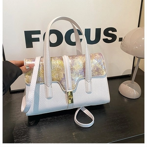 Detail of white faux snake leather handbag with golden floral embossed flap and square lock