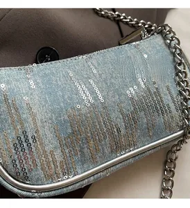 Close-up of light blue denim chain bag with silver sequins and metallic details