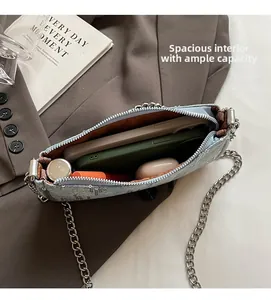 Internal view of blue denim crossbody bag with phone, lipstick and silver chain detail