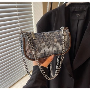 Detail of denim shoulder bag with silver sequins and metallic chain straps