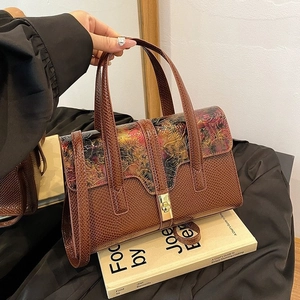 Detail of vintage brown textured leather handbag with colorful embossed floral pattern