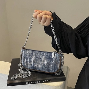 Retro denim baguette bag with silver sequins and metallic chain strap on a white background