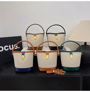 Detailed shot of five canvas bucket bags with leather trim and gold twist locks