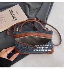 Detail of denim bag showing multi-compartment interior and gray herringbone fabric lining