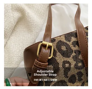 Detail of adjustable leather strap and gold buckle on leopard print crossbody bag