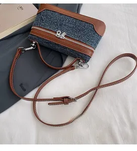 Detail of adjustable leather strap and denim stitching on the vintage shoulder bag
