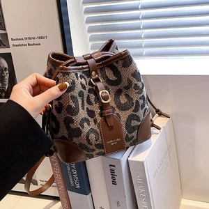 Detail of leopard print bucket bag with drawstring closure and brown leather trim