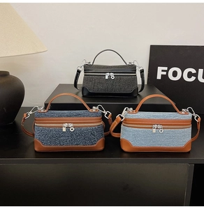 Close-up of denim texture crossbody bags with contrast stitching and metal zipper detail
