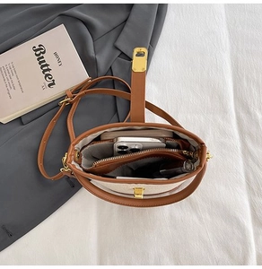 Top view of bucket bag interior showing smartphone and lipstick in organized sections
