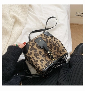 Detail of leopard print jacquard bucket bag featuring black leather trim and metal buckle