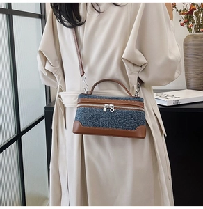 Detail of denim and leather stitching on retro contrast crossbody bag with double zippers