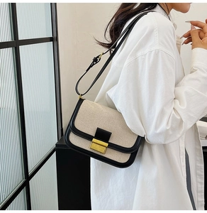 Side view of model wearing a contrast canvas crossbody bag with gold buckle detail