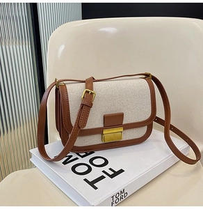 Close-up of retro beige canvas and brown leather crossbody bag with golden square clasp