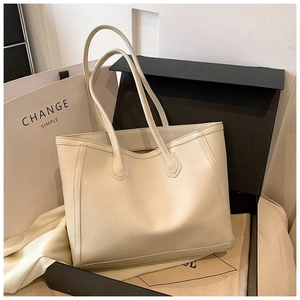 Close-up of off-white cream tote bag featuring premium lychee pattern leather and stitching