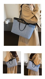 Detail of blue denim tote bag with black leather straps and contrast trim stitching