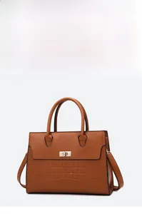 Detail of caramel tote with crocodile pattern, golden twist lock and sturdy handles