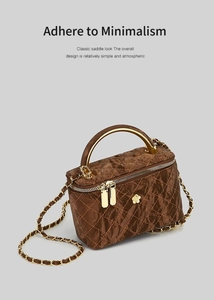 Detailed view of dark coffee quilted handbag with gold metal handle and chain strap