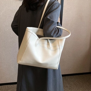 Close-up of white lychee pattern leather tote bag with elegant dual handle details