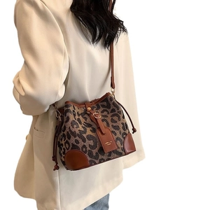 Leopard print bucket bag with brown leather trim and drawstring for a vintage look