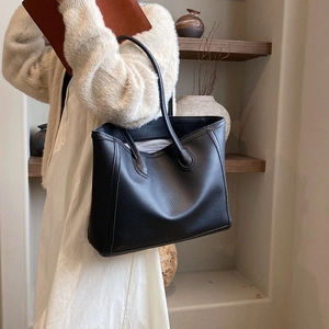 Black lychee texture tote bag shown on model for stylish daily commuting and casual look