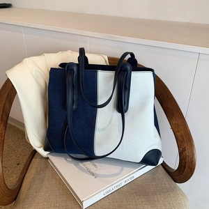 Large denim tote bag with leather trim and contrast stitching for stylish commuting