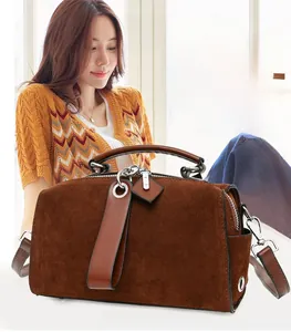 Dettaglio borsa Boston in camoscio marrone con manici in pelle e metallo argento