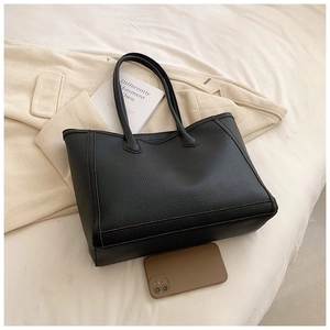 Close-up of black pebbled leather tote bag showing textured finish and spacious design