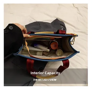 Intérieur spacieux du cabas en toile denim avec sangles marron et détail de fermeture dorée