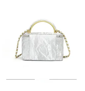 Detailed back view of silver quilted crossbody bag with gold handle and chain strap
