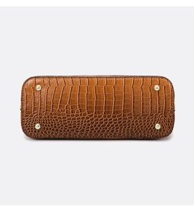 Detail of brown crocodile pattern shoulder bag with four gold-tone metal protective feet