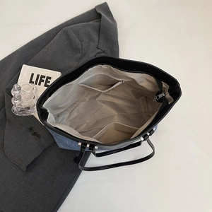 Spacious tote bag with denim and leather contrast shown from top view with interior pockets