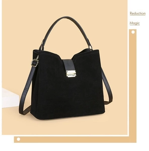 Detail view of black suede bucket bag with leather straps and golden metal hardware